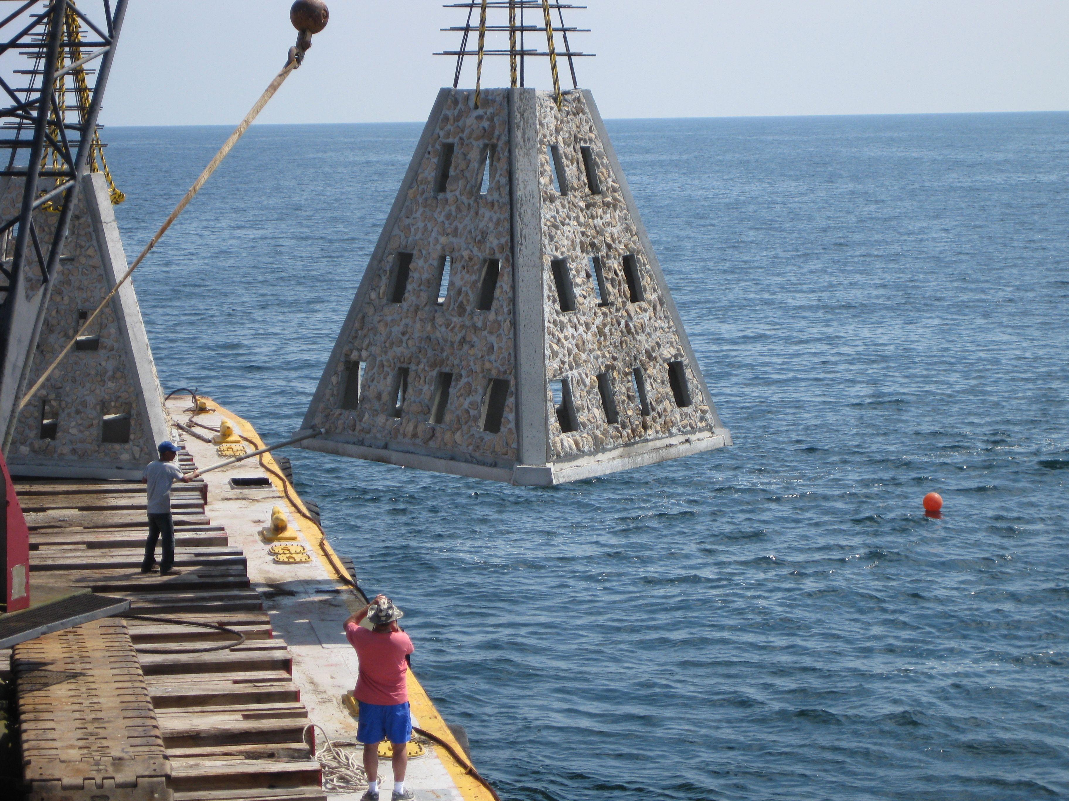 Crane deploying a large Super Reef module from a marine construction vessel
