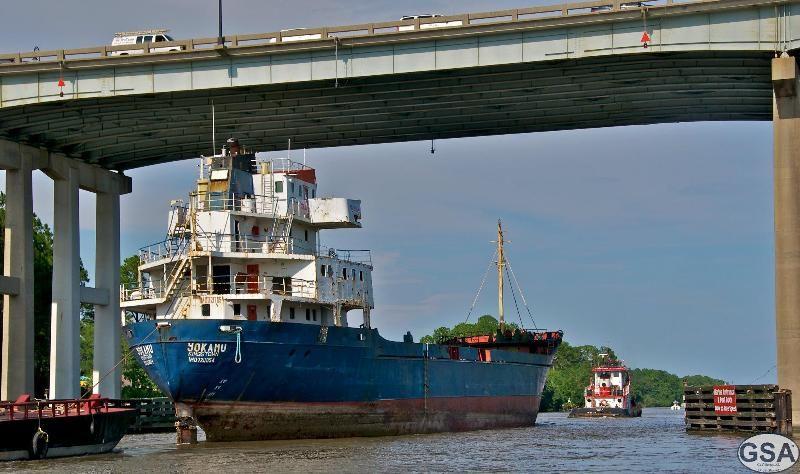 Marine construction vessel passing beneath a bridge