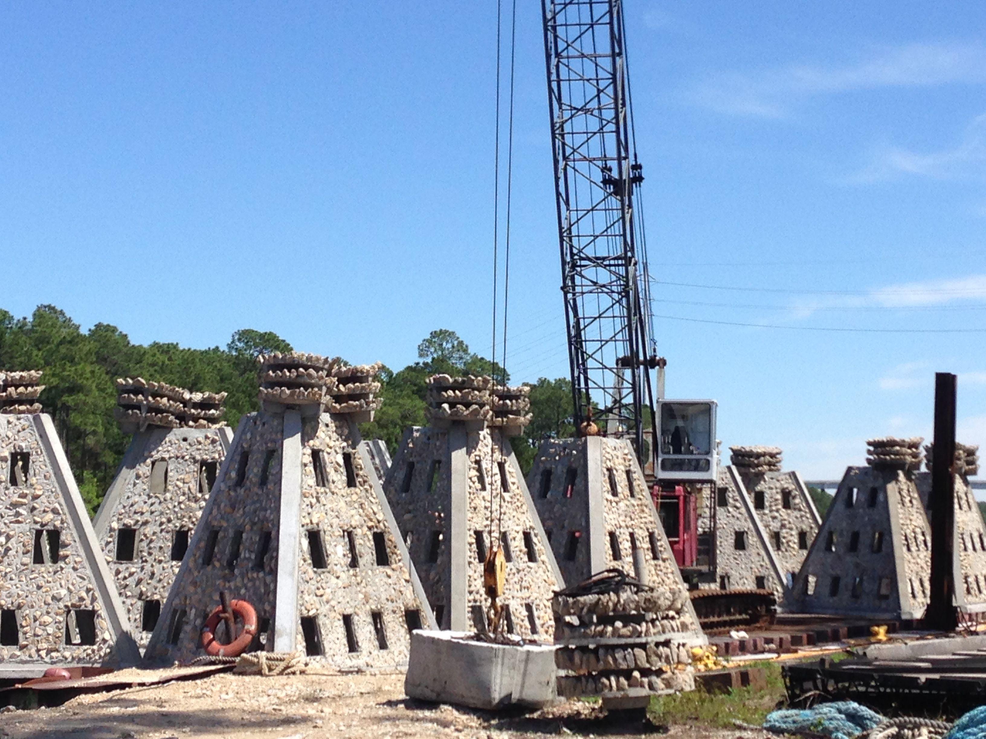 Rows of Super Reef modules staged near marine lifting equipment before deployment