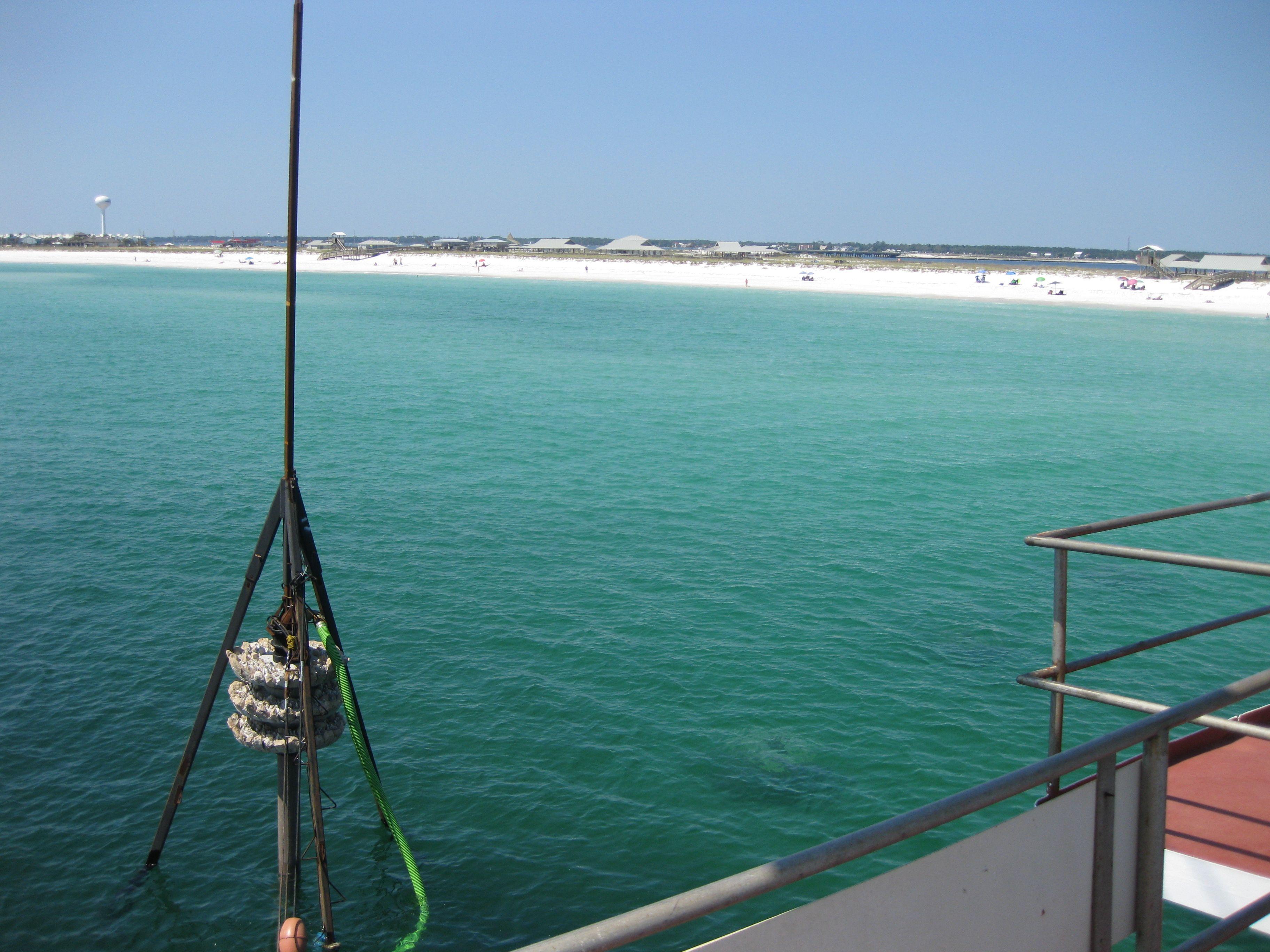 Small artificial reef structure suspended over the water from a vessel crane
