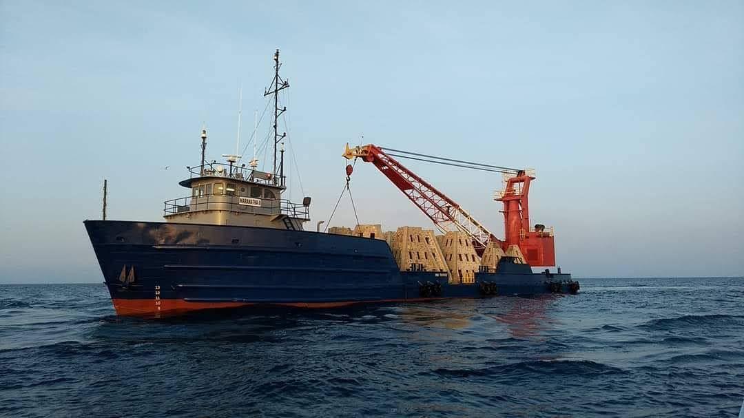 Marine construction vessel operating a crane in calm water