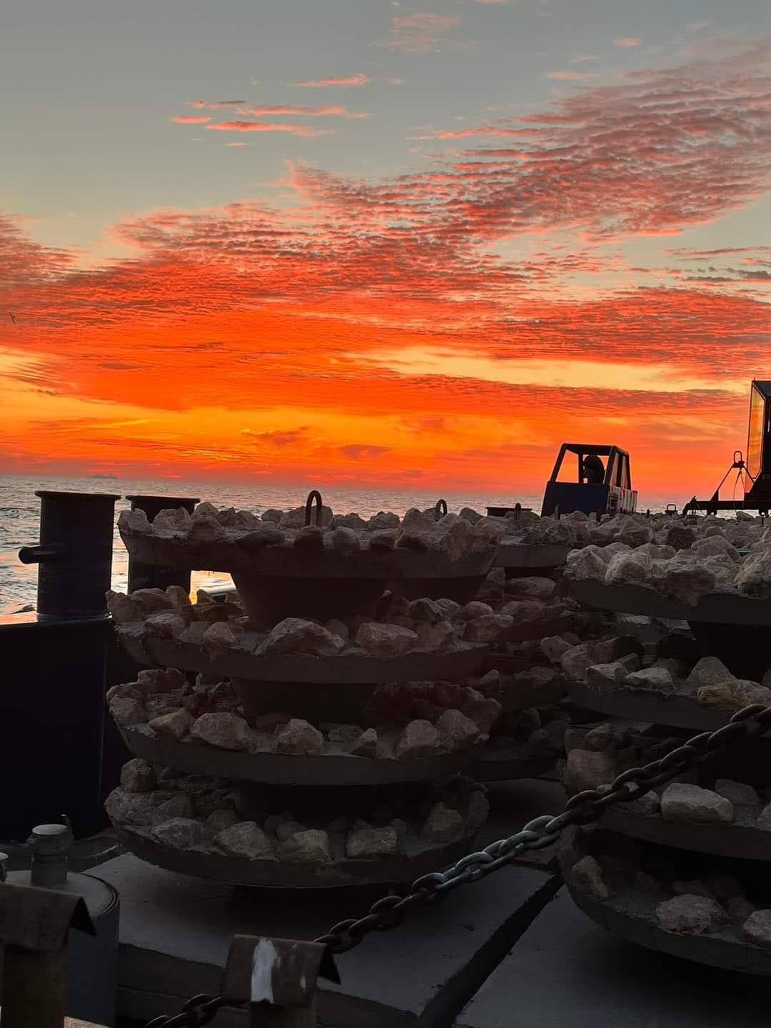 Rows of artificial reef modules silhouetted at sunset